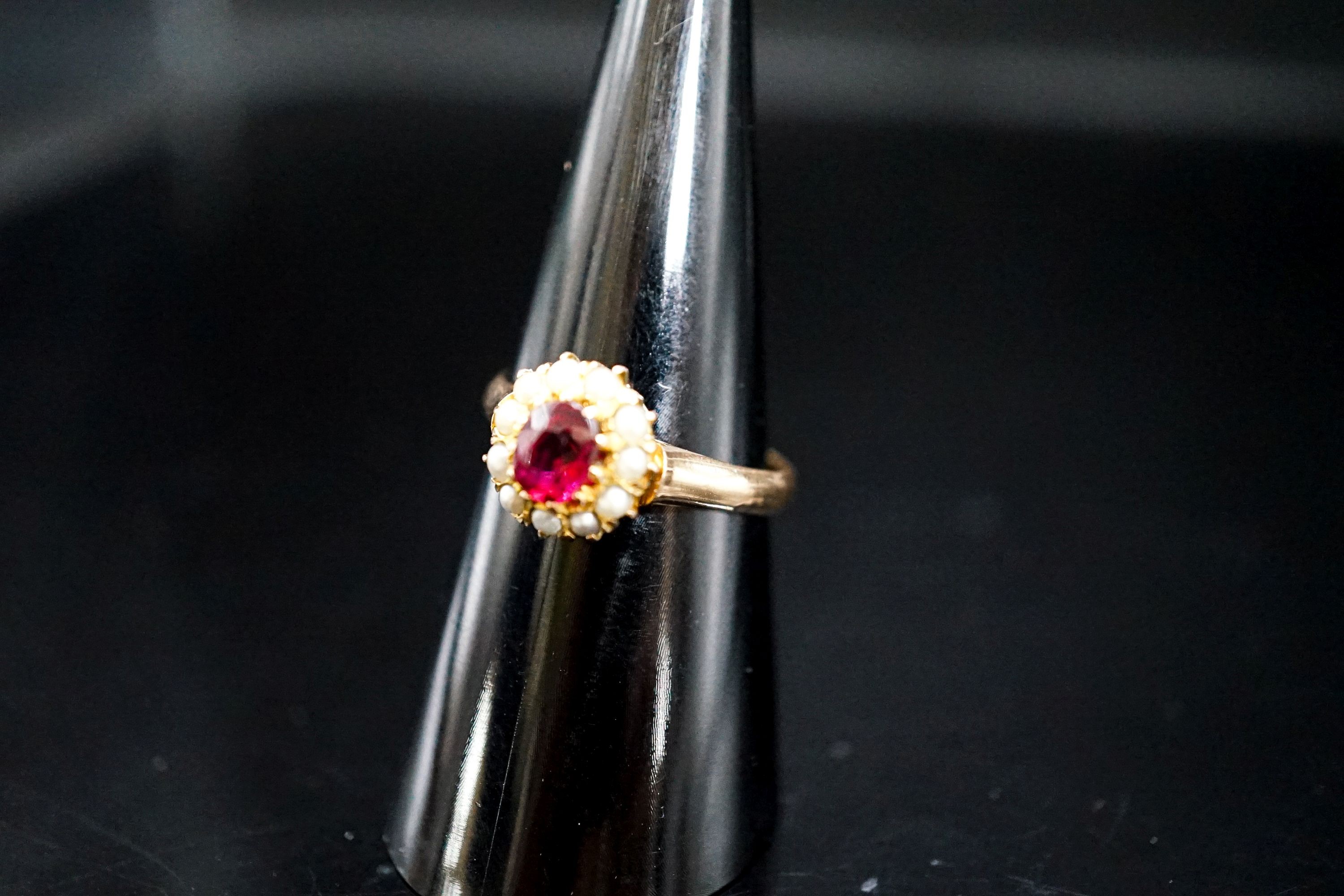 A yellow metal, ruby and seed pearl circular cluster ring, size N, gross weight 3.2 grams.